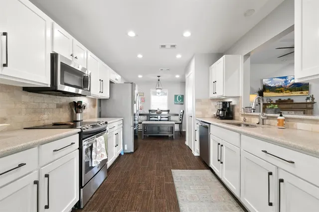 a kitchen with stainless steel appliances granite countertop a stove a sink dishwasher and a refrigerator