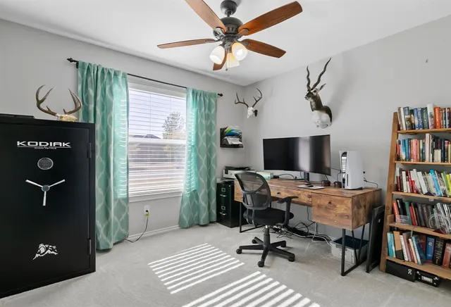 a view of a workspace with furniture and a bookshelf