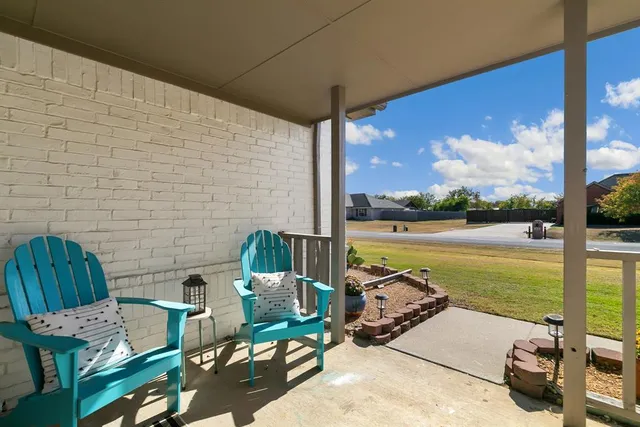 a view of a patio with lawn chairs next to a yard