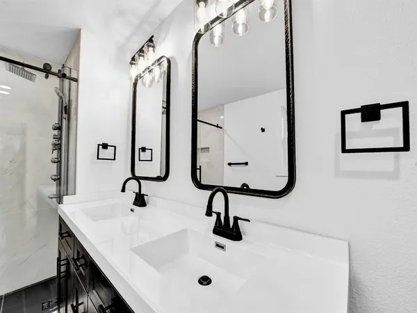 a bathroom with double vanity sink and a mirror