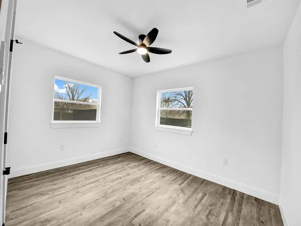 a view of empty room with wooden floor