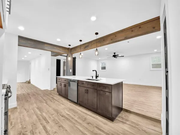 a large kitchen with a sink stainless steel appliances and cabinets