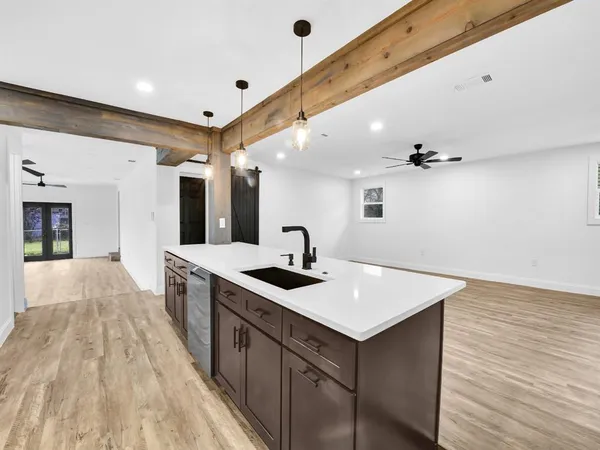 a view of a kitchen counter space with sink and wooden floor