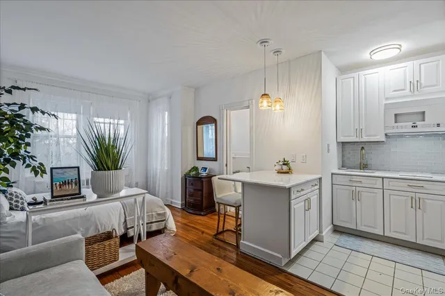 a kitchen with a sink dishwasher a stove a kitchen island with chairs and cabinets