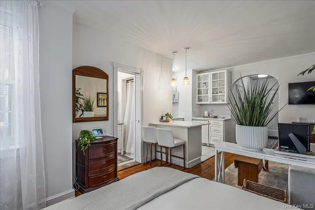 a living room with furniture a computer on the desk and a flat screen tv