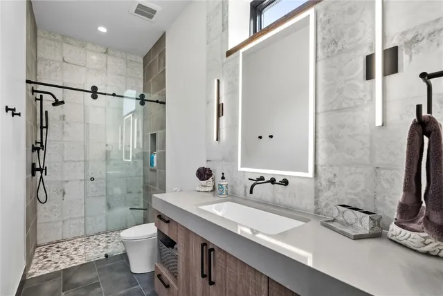 a bathroom with a double vanity sink toilet and shower