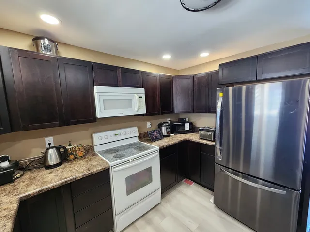 a kitchen with a refrigerator sink and cabinets