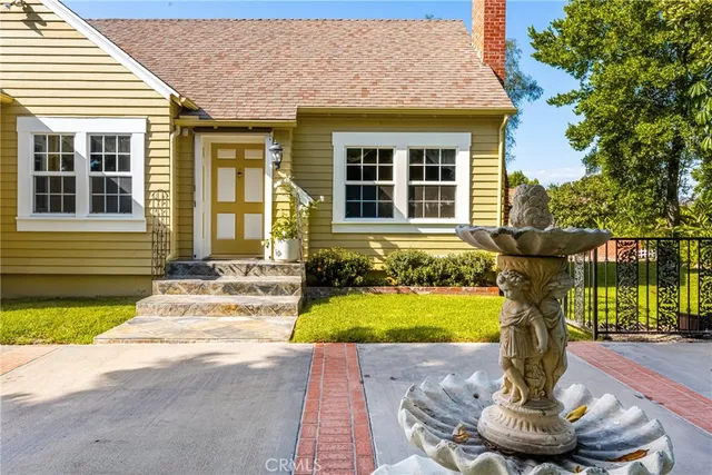 a front view of a house with a yard fountain and a fire pit