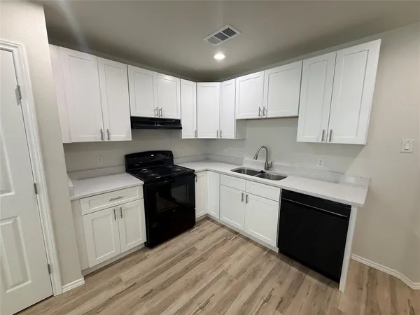 a kitchen with a sink a stove a refrigerator and cabinets