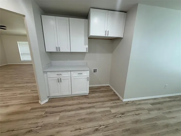 a view of a kitchen with white cabinets