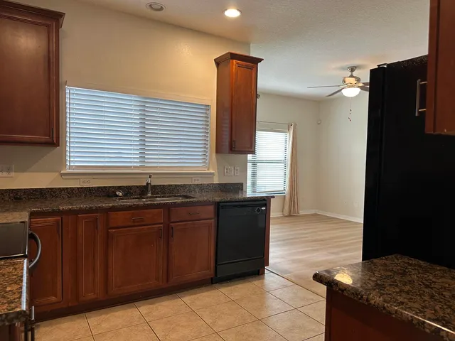 a kitchen with granite countertop a stove and a sink