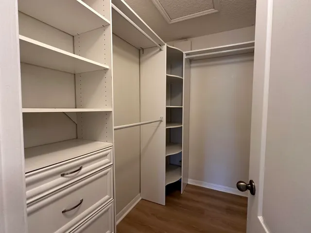 a view of walk in closet with empty racks