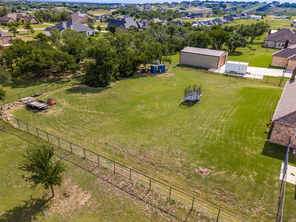 6913 Veal Station Road Weatherford, TX 76085 - Photo 30 of 31 Expansive green lot featuring a metal building, concrete drive, and surrounding fencing