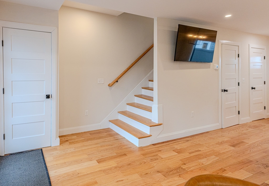 1-7 Wilcutt Road, Unit 5 Boston, MA 02121 - Photo 9 of 24 a view of an empty room with wooden floor and stairs