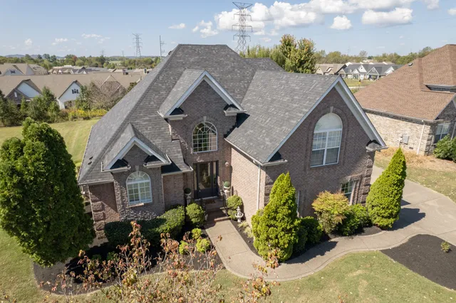 a view of a white house next to a yard