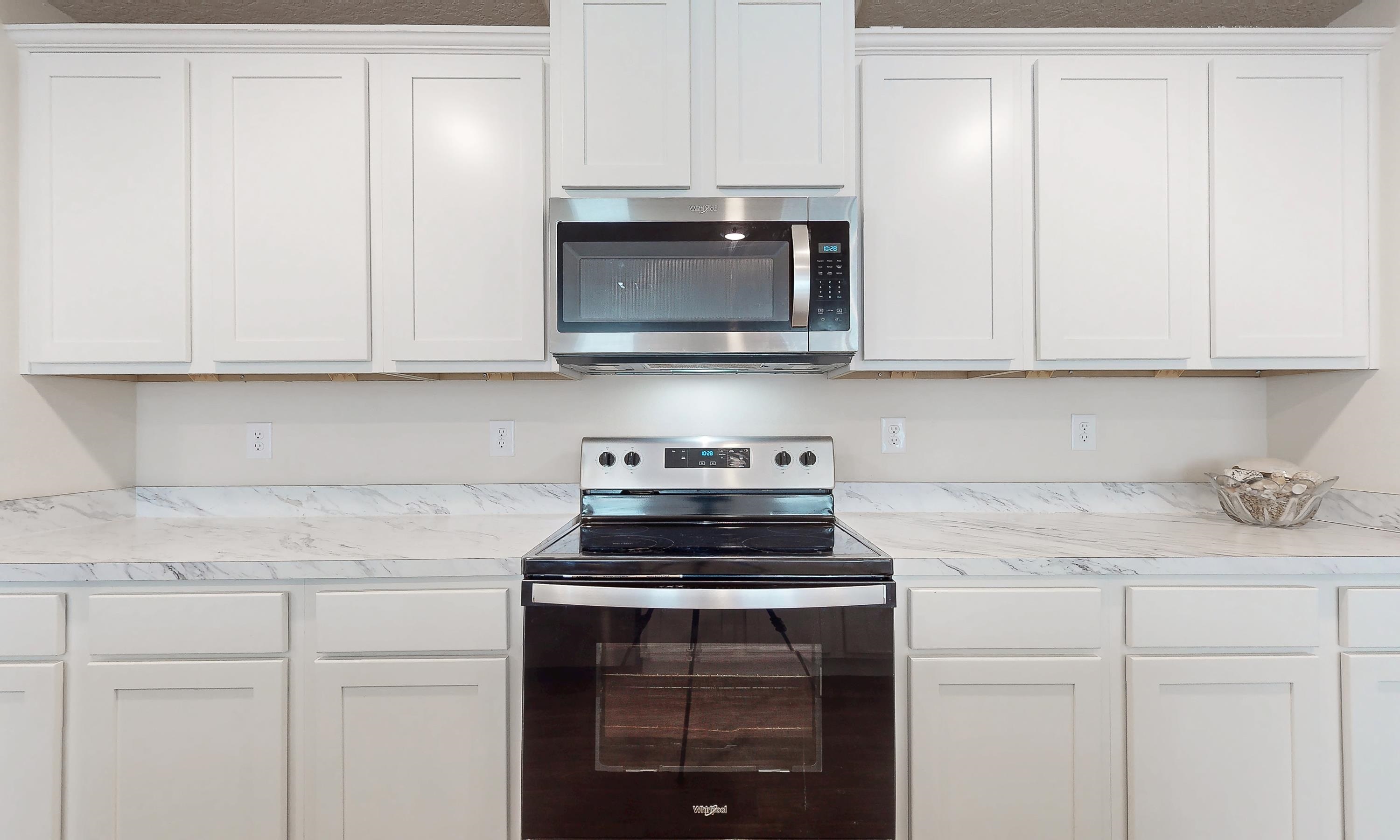 233 Falcon Ridge Road St. Augustine, FL 32084 - Photo 13 of 41 a kitchen with granite countertop white cabinets and a stove top oven