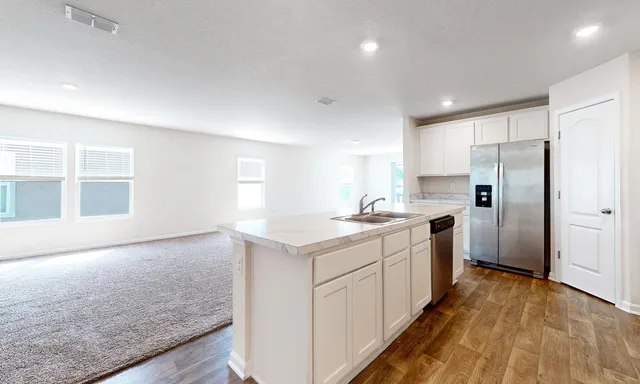 a kitchen with a sink a counter top space stainless steel appliances and cabinets
