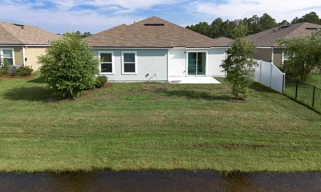 an aerial view of residential houses with outdoor space and lake view