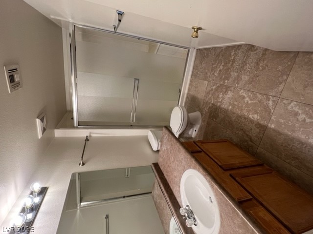 7255 West Sunset Road, Unit 1124 Las Vegas, NV 89113 - Photo 4 of 18 Tiled flooring pairs with a wooden vanity in this functional bathroom layout.