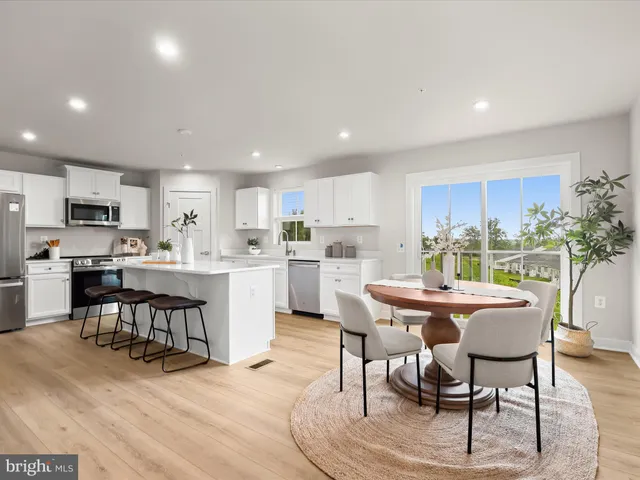 a kitchen with a dining table chairs and white cabinets