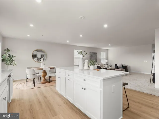 a kitchen with stainless steel appliances granite countertop a stove a sink a island and chairs in it