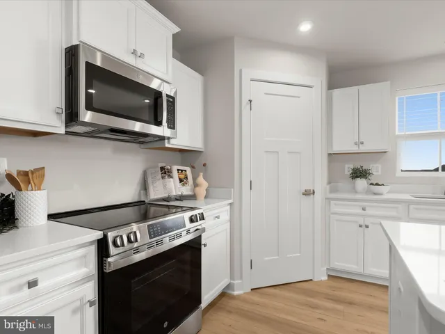 a kitchen with stainless steel appliances and white cabinets