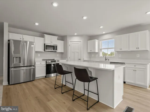 a kitchen with a refrigerator a counter top space and a sink stainless steel appliances