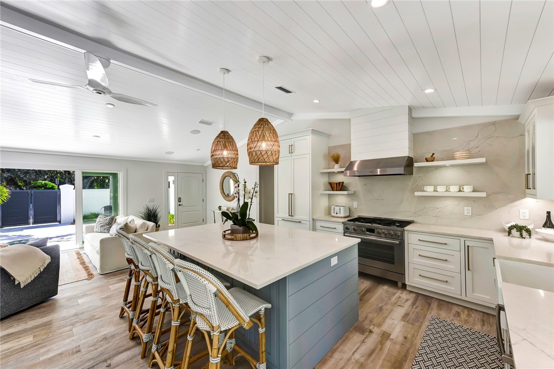 525 Banyan Road Vero Beach, FL 32963 - Photo 14 of 36 a kitchen with stainless steel appliances a stove a sink dishwasher a dining table and chairs with wooden floor