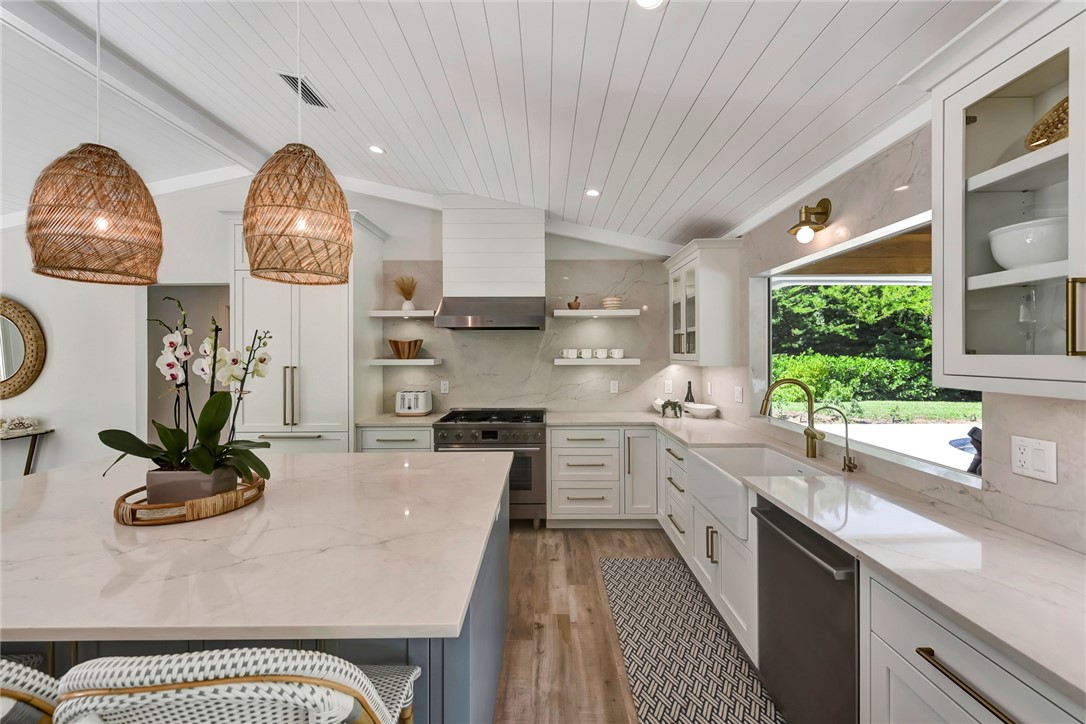 525 Banyan Road Vero Beach, FL 32963 - Photo 17 of 36 a kitchen with stainless steel appliances a dining table a stove a microwave a refrigerator and cabinets