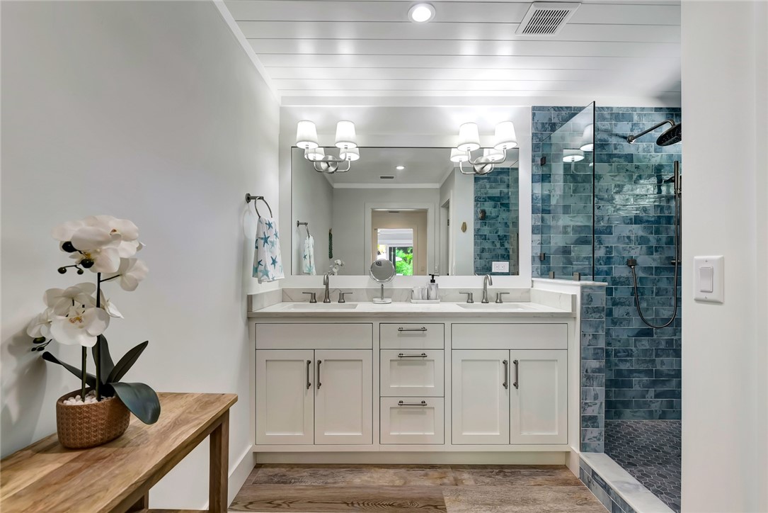 525 Banyan Road Vero Beach, FL 32963 - Photo 22 of 36 a bathroom with a sink a light fixture and a glass door