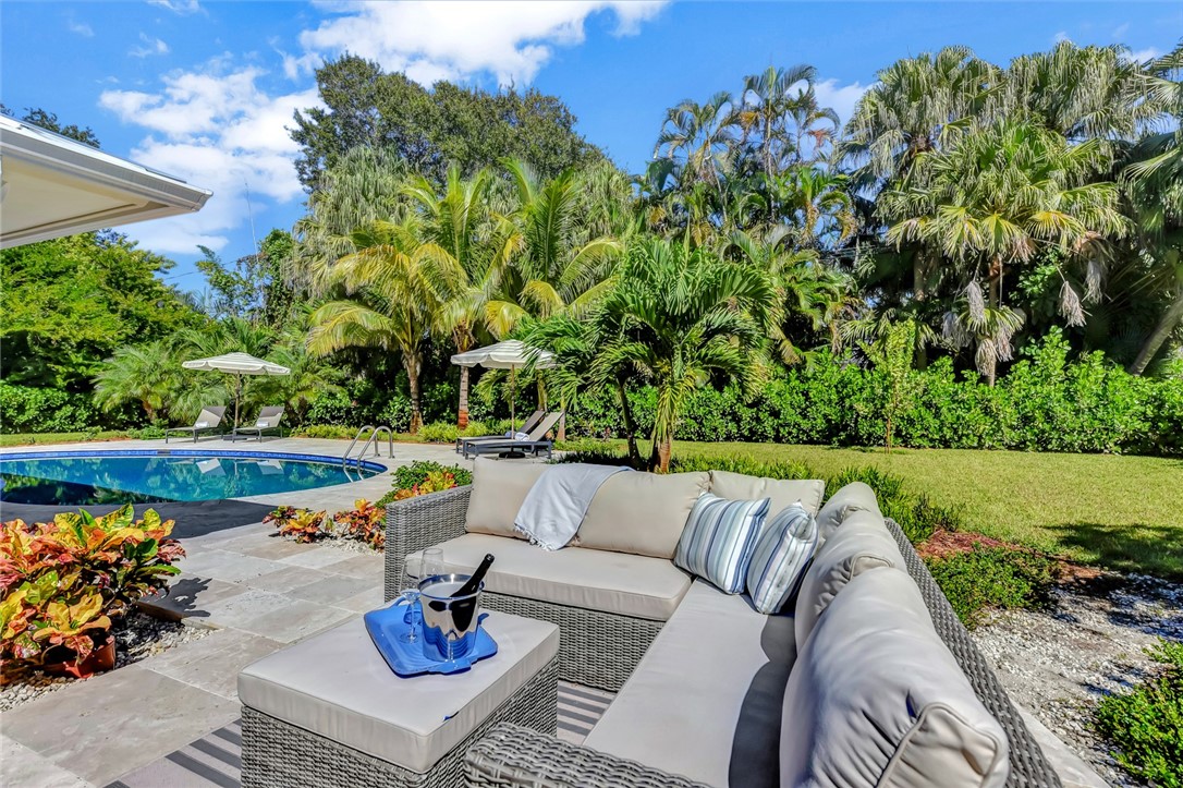 525 Banyan Road Vero Beach, FL 32963 - Photo 28 of 36 a view of swimming pool with seating space and trees in the background