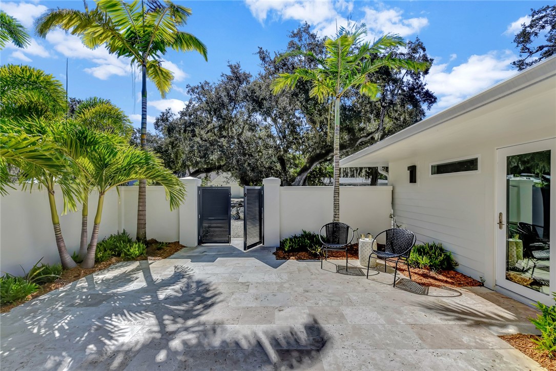 525 Banyan Road Vero Beach, FL 32963 - Photo 6 of 36 a couple of table and chairs in front of a white house
