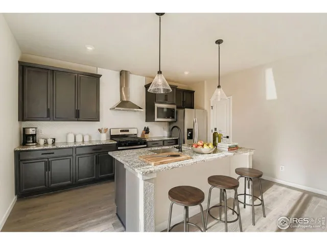 a kitchen with stainless steel appliances kitchen island granite countertop a refrigerator a stove a sink dishwasher with a dining table and chairs