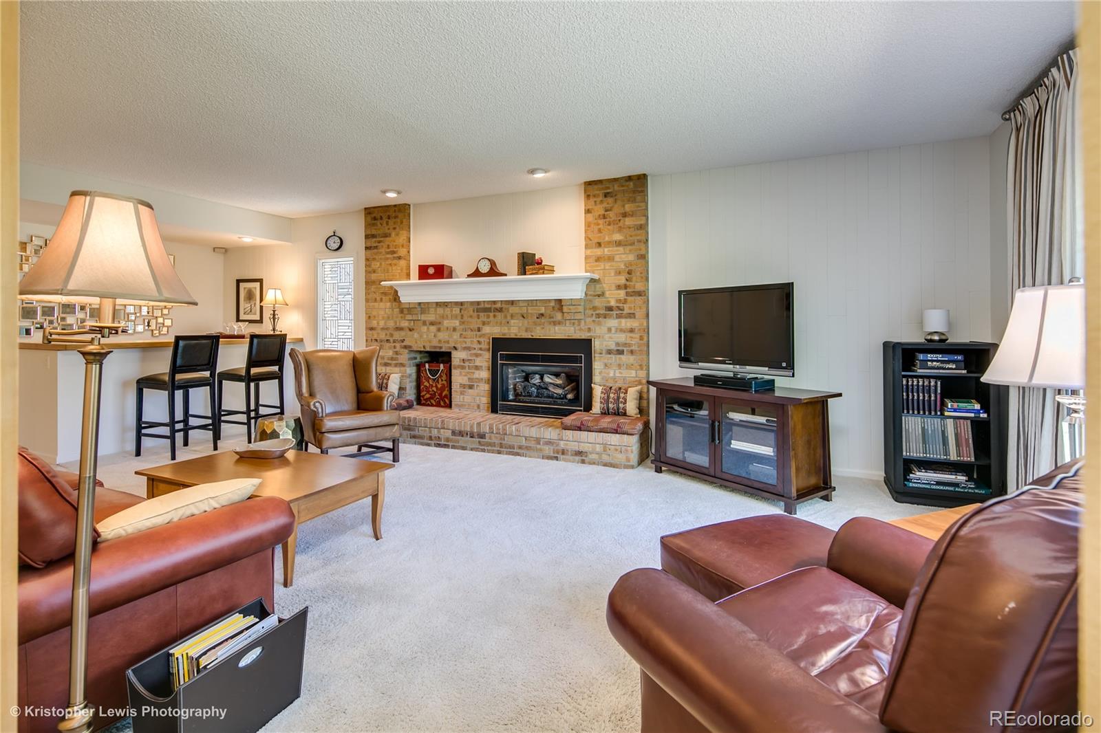 8247 Lodgepole Trail Lone Tree, CO 80124 - Photo 13 of 35 a living room with furniture a fireplace and a flat screen tv