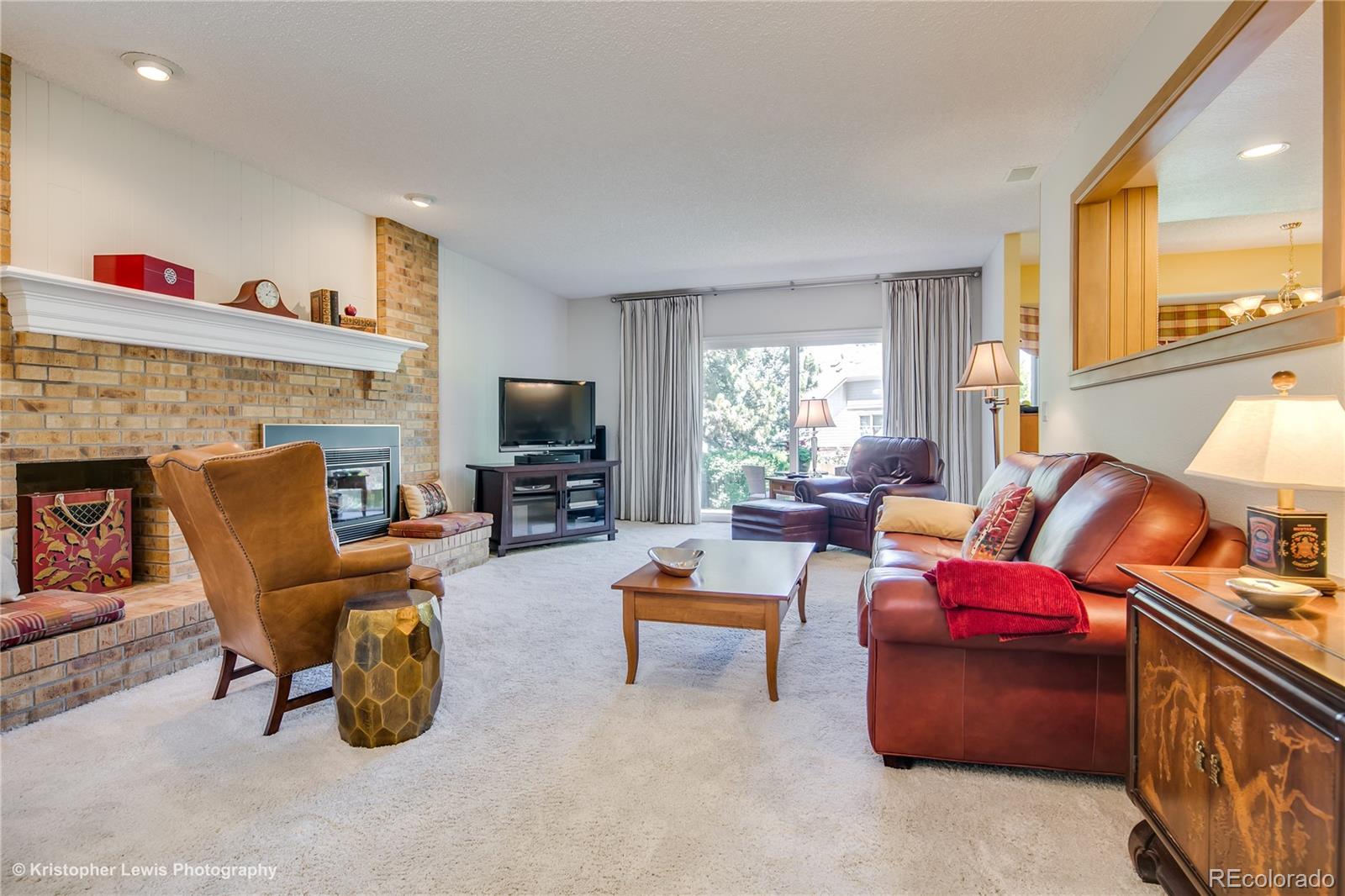 8247 Lodgepole Trail Lone Tree, CO 80124 - Photo 15 of 35 a living room with furniture a flat screen tv and a fireplace