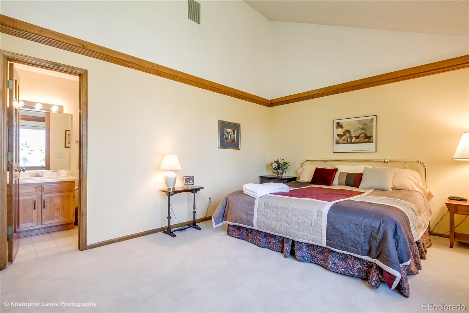 8247 Lodgepole Trail Lone Tree, CO 80124 - Photo 25 of 35 a bedroom with a bed and a chandelier