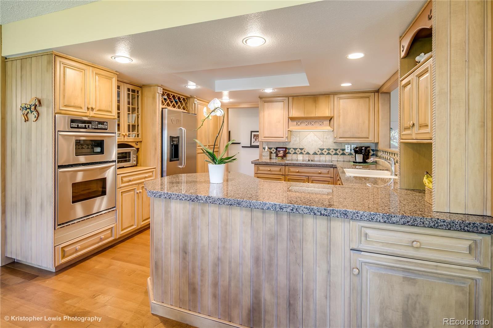 8247 Lodgepole Trail Lone Tree, CO 80124 - Photo 9 of 35 a kitchen with stainless steel appliances granite countertop a stove a sink and a microwave