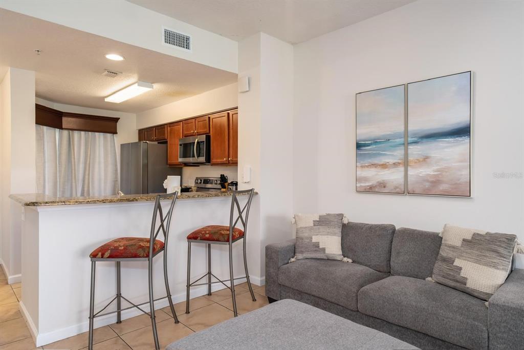 8763 Worldquest Boulevard, Unit 5406 Orlando, FL 32821 - Photo 13 of 25 a living room with furniture a flat screen tv and a window
