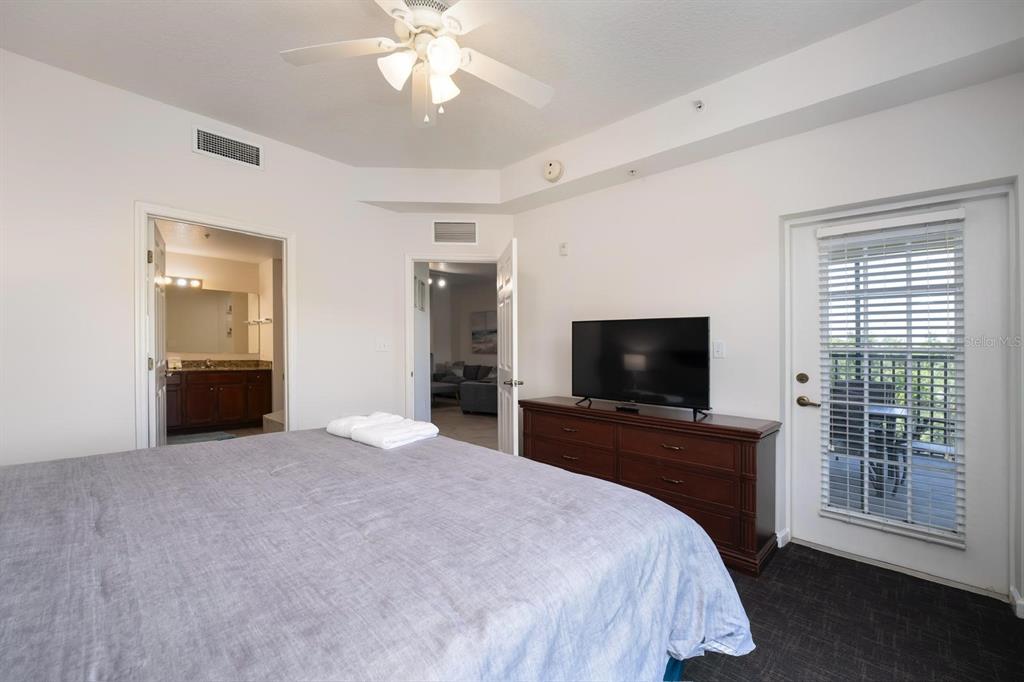 8763 Worldquest Boulevard, Unit 5406 Orlando, FL 32821 - Photo 19 of 25 a bedroom with a bed and a flat screen tv