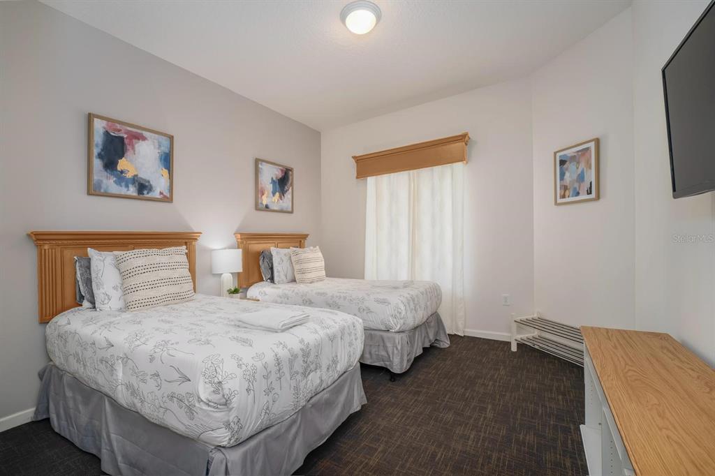 8763 Worldquest Boulevard, Unit 5406 Orlando, FL 32821 - Photo 20 of 25 a bedroom with a bed and a lamp