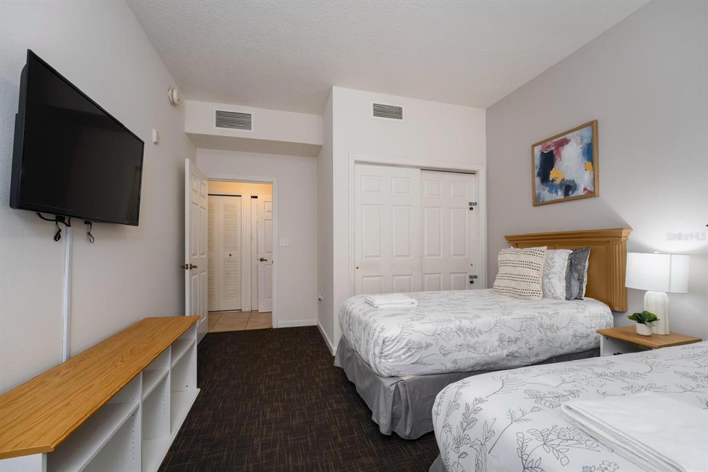 8763 Worldquest Boulevard, Unit 5406 Orlando, FL 32821 - Photo 21 of 25 a bedroom with two beds and a flat screen tv