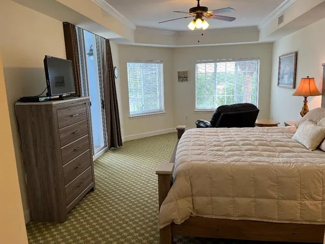 a bedroom with a bed a window and dresser