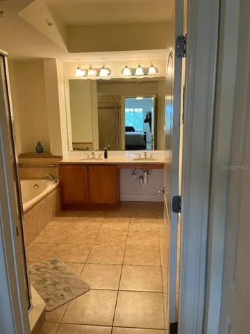 a large bathroom with a tub and sink