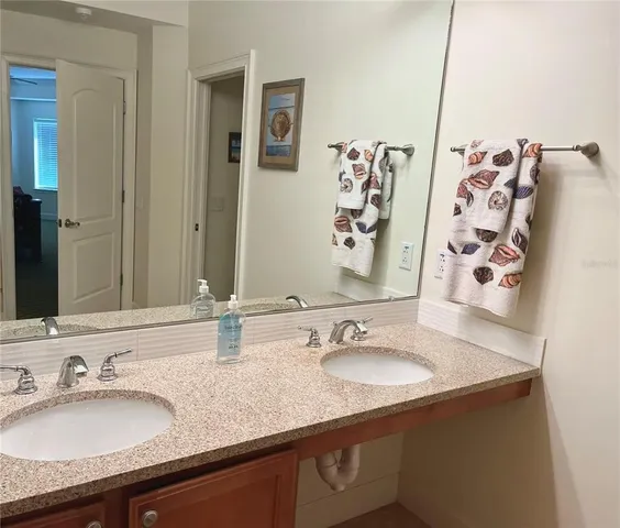 a bathroom with a granite countertop sink and a mirror