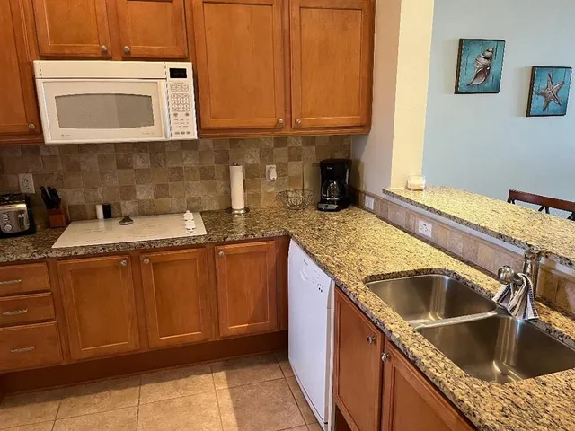 a kitchen with granite countertop a sink and a stove top oven