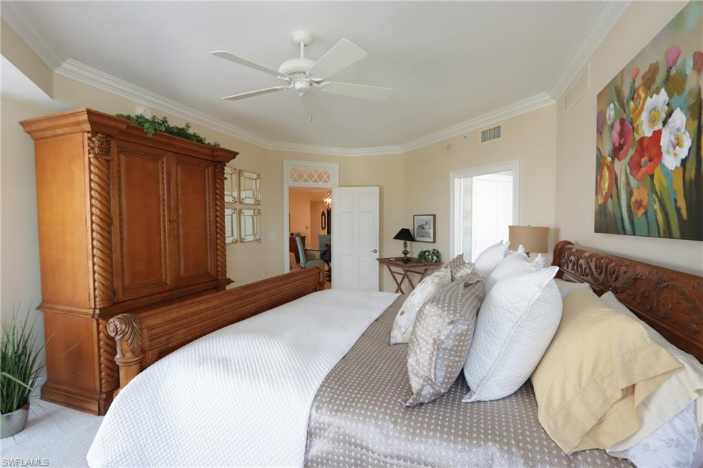 60 Seagate Drive, Unit 402 Naples, FL 34103 - Photo 12 of 26 a bedroom with a bed and a painting on the wall