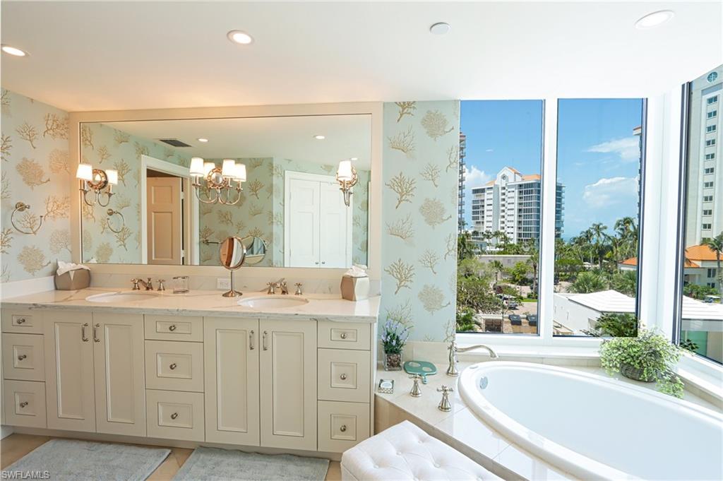60 Seagate Drive, Unit 402 Naples, FL 34103 - Photo 14 of 26 a spacious bathroom with a granite countertop sink mirror and a bathtub