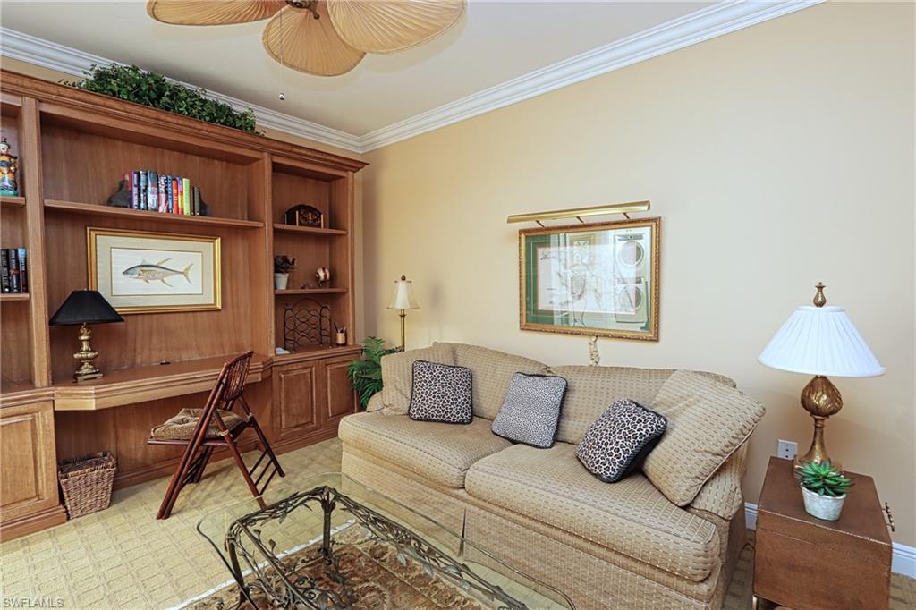 60 Seagate Drive, Unit 402 Naples, FL 34103 - Photo 20 of 26 a living room with furniture and a lamp