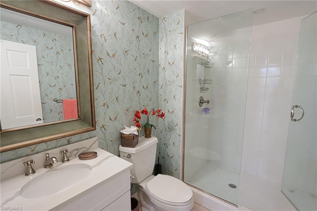 60 Seagate Drive, Unit 402 Naples, FL 34103 - Photo 22 of 26 a bathroom with a sink toilet and shower
