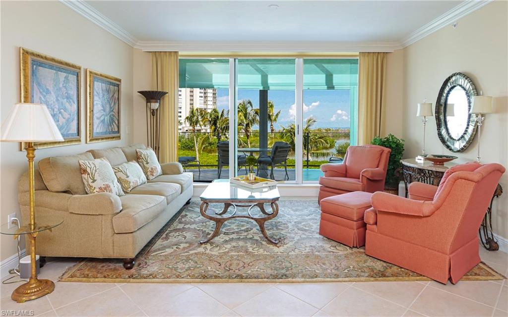 60 Seagate Drive, Unit 402 Naples, FL 34103 - Photo 4 of 26 a living room with furniture and a large window